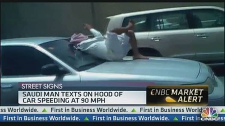 Saudi Man Texting on Hood of Car