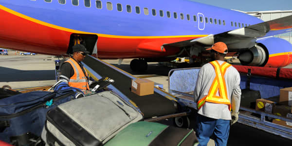 Business travelers hop off luggage carousel, ship bags