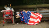 A homeless man sleeps on a park bench in the Brooklyn borough of New York.