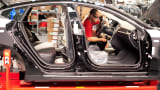 An employee works on a Telsa Model S sedan on an assembly line at the company's assembly plant in Fremont, Calif.