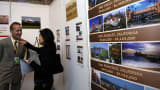 A salesperson introduces properties to a potential buyer at the Sino-U.S. Real Estate Exhibition Fair in Beijing.