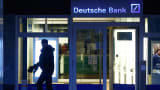 A pedestrian passes a Deutsche Bank branch in Frankfurt, Germany.