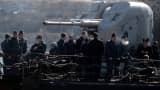 Ukrainian soldiers stand guard on board the navy corvette Ternopil as Russian forces patrol nearby in the harbor of the Ukrainian city of Sevastopol on March 5, 2014.
