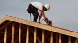 A worker uses a saw on a roof while building a new home at the Toll Brothers Inc. Baker Ranch community development in Lake Forest, California, Feb. 11, 2014.