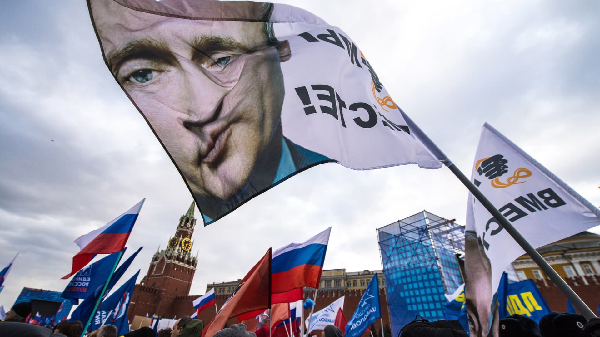 With a flag depicting President Vladimir Putin, pro-Kremlin activists rally in Red Square, Moscow, March 18, 2014, to celebrate the incorporation of Crimea.
