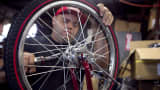 An employee assembles front-end brakes to a bicycle frame at Worksman Cycles in Queens, New York.