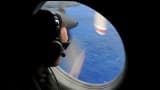 A crew member of a Royal New Zealand Airforce helps to look for objects during the search for missing Malaysia Airlines flight MH370.