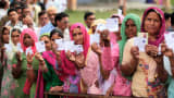 Voters showing their ID cards as they stand in a queue to cast their votes at a polling station on April 17, 2014 in Jammu, India.