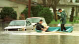 Residents of Petaluma, California, paddle through their neighborhood in February 1998, after El Nino storms caused flooding and mudslides in Northern California.