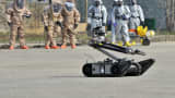 Soldiers of the US Army's 23rd Chemical Battalion (background) wear protective gear to give a demonstration of their equipment as iRobot PackBot (front) moves during a ceremony to recognise their official return to the 2nd Infantry Division located in South Korea, at Camp Stanley in Uijeongbu, north of Seoul, on April 4, 2013.