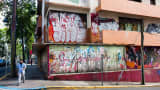 A man walks past a vacant building in the Santurce neighborhood of San Juan, Puerto Rico.