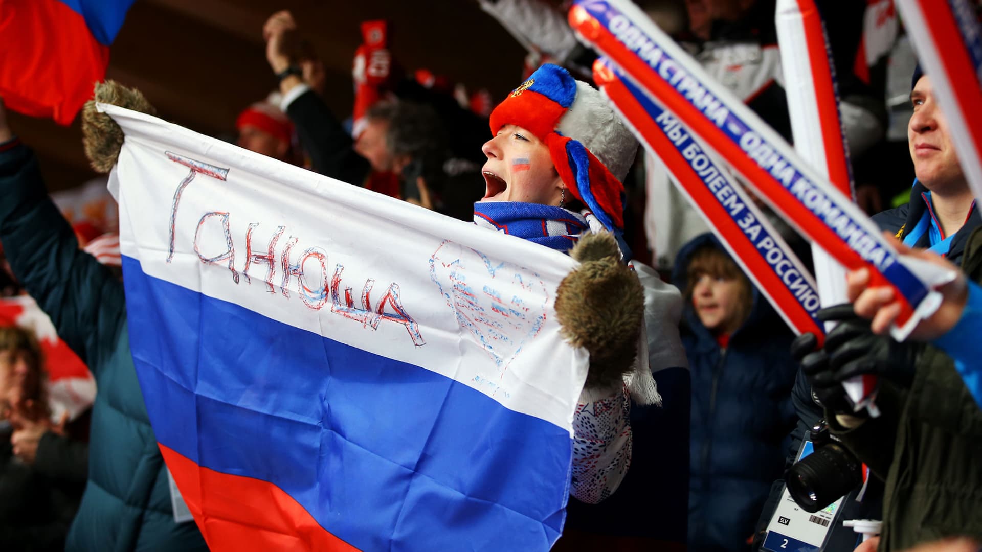 A fan holds up a Russian flag during the luge relay event at the 2014 Winter Olympic Games in Sochi, Russia.