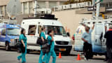 Television trucks outside Mount Sinai Hospital, August 4, 2014, in New York, after officials announced a male patient who recently traveled to West Africa is being tested for the Ebola virus.