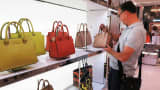 A shopper looks at Michael Kors handbags at Macy's in New York City.