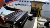 A ground crew member loads baggage onto a Spirit Airlines plane at the San Diego International Airport.
