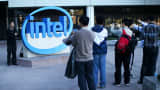 Visitors take pictures next to the Intel logo at Intel headquarters in Santa Clara, Calif.