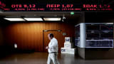 A visitor walks beneath a display at the Athens Stock Exchange, Oct. 15, 2014.