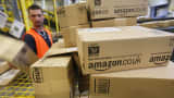 A worker prepares packages for delivery at an Amazon warehouse in Brieselang, Germany.