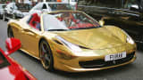 A gold Ferrari drives through the Knightsbridge section of London, Aug. 8, 2014.