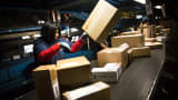 FedEx workers sort packages at a FedEx global hub.