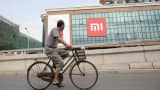 A man rides a bicycle past the Xiaomi offices in Beijing.