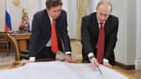 Russia's President Vladimir Putin (R) speaks with Russian gas monopoly Gazprom CEO Alexei Miller.