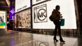 A pedestrian passes by a Michael Kors retail store in New York.