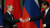 Russian President Vladimir Putin (L) greets Chinese President Xi Jinping