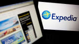 The Expedia homepage and logo are displayed on laptop computers.
