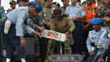 Indonesian officers move the flight data recorder of the AirAsia flight QZ8501