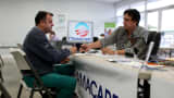 A customer for heath insurance under the Affordable Care Act sits with an advisor with UniVista Insurance in Miami.