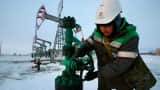 A worker checks the valve of an oil pipe at an oil field near the village of Nikolo-Berezovka, Russia.
