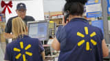 Employees assist shoppers at the checkout counter of a Walmart store in Los Angeles.