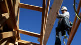 A worker carries lumber as he builds a new home in Petaluma, California.