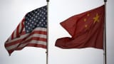 National flags of the U.S. and China fly outside a company building in the China (Shanghai) Pilot Free Trade Zone in Shanghai, China on Oct. 22, 2013.