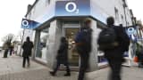 Pedestrians pass an O2 mobile phone store, operated by Telefonica SA, in London, U.K.