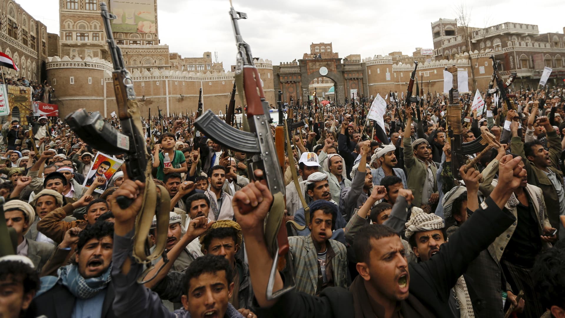 Shi'ite Muslim rebels hold up their weapons during a rally against air strikes in Sanaa March 26, 2015.