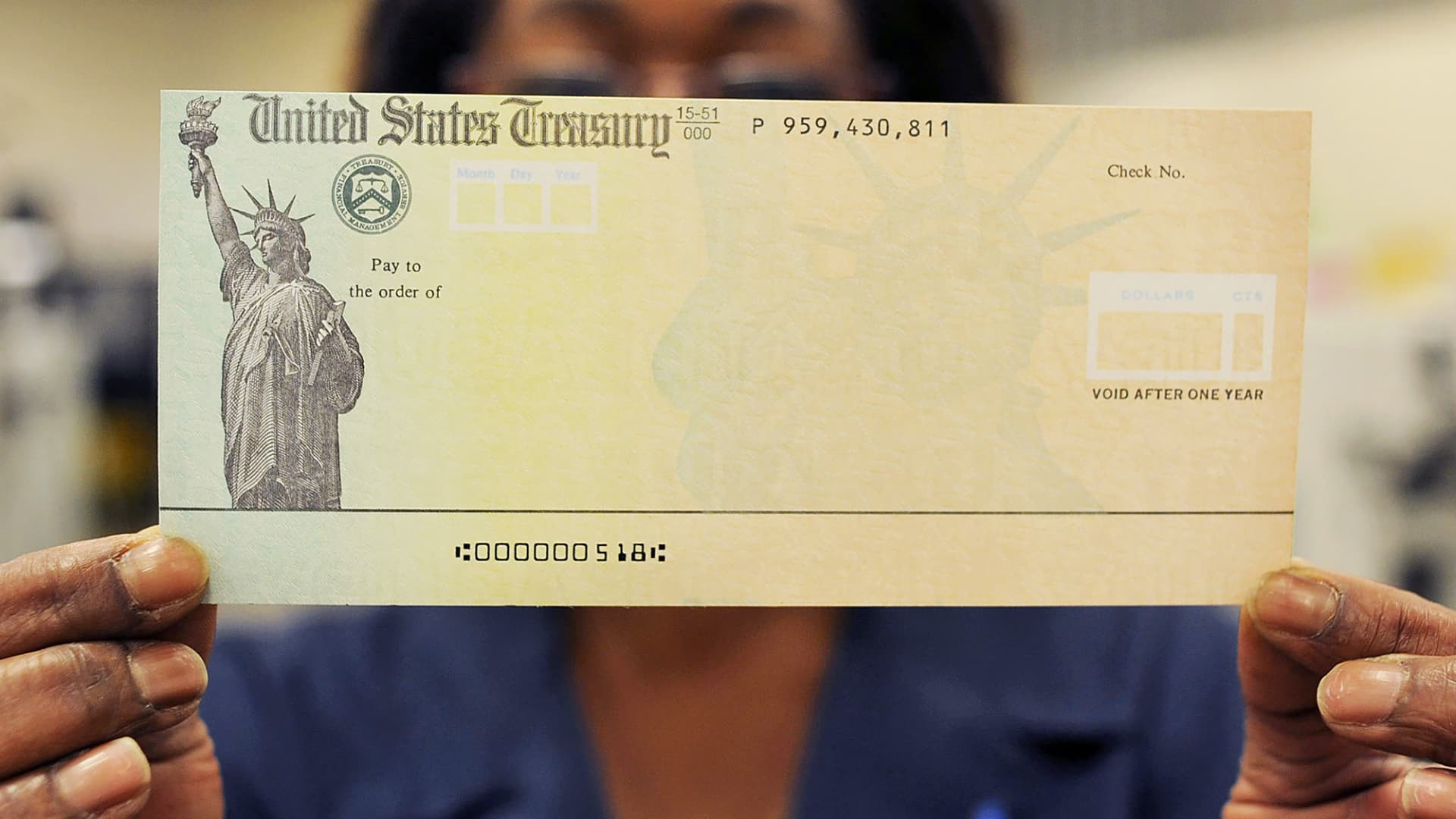 An employee holds a blank U.S. Treasury check before it's run through a printer at the U.S. Treasury printing facility in Philadelphia.