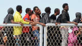 Migrants wait to disembark from military ship 'Bettica' after a rescue operation at sea on May 5, 2015 in the port of Salerno, southern Italy.