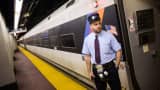 NJ Transit conductor John Nagle waits for passengers to board the NJ Transit train from New York’s Penn Station to Trenton, N.J., May 13, 2015, in New York.