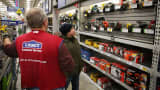 An employee helps a customer shop for a sander at a Lowe's home improvement store in Chicago.