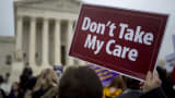 A demonstrator holds a sign in support of President Barack Obama's health-care law, Obamacare, in front of the U.S. Supreme Court in Washington, on Wednesday, March 4, 2015.