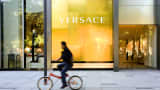 A man rides a bicycle past a Gianni Versace store in Beijing, China.