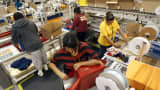 Workers gift-wrap orders for delivery at Amazon's distribution center in Phoenix, Arizona.