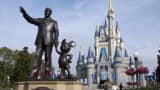 A statue of Walt Disney and Mickey Mouse stands in front of the Cinderella's castle at Walt Disney World's Magic Kingdom in Lake Buena Vista, Florida.