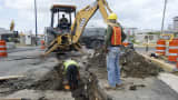 Construction workers dig a trench on a waterfront street in Old San Juan, Puerto Rico.