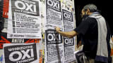 A man puts up referendum campaign posters with the word "No" in Greek in Athens, Greece, July 1, 2015.