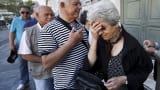A pensioner reacts after receiving a priority ticket to receive part of their pensions outside a bank in Athens, Greece, July 2, 2015.