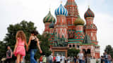Tourists explore Red Square in front of St. Basil's Cathedral in Moscow.