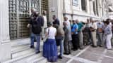 People wait to enter a bank branch as Greek banks reopened on Monday morning after three weeks of closure on July 20, 2015 in Athens, Greece.